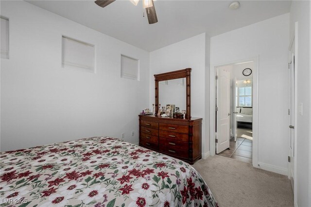 carpeted bedroom with ensuite bath and ceiling fan