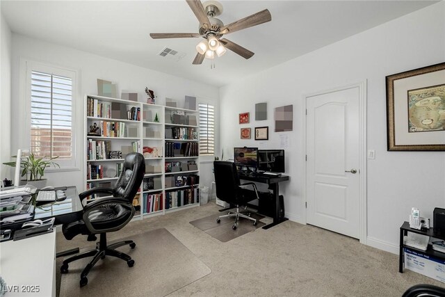 home office with ceiling fan and light carpet