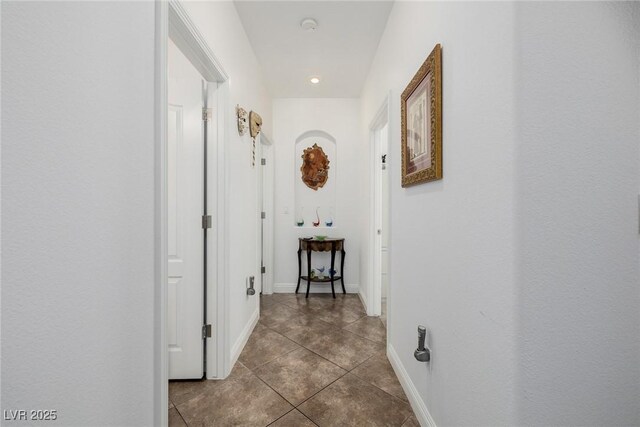 hallway featuring dark tile patterned floors