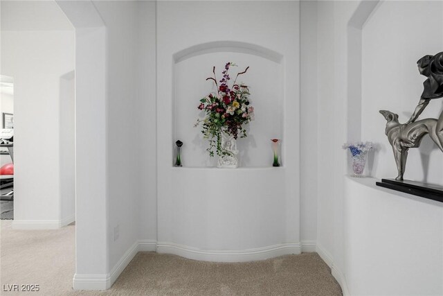 hallway featuring light colored carpet