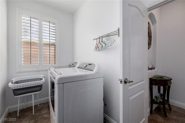 clothes washing area featuring washer and clothes dryer and dark tile patterned flooring