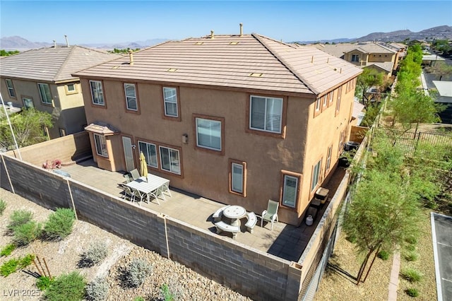 back of house with a mountain view and a patio