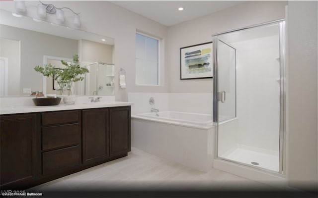 bathroom with tile patterned flooring, vanity, and shower with separate bathtub