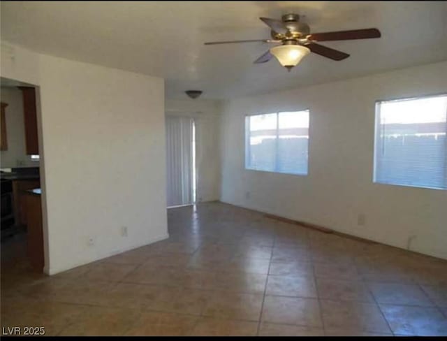 empty room with ceiling fan and plenty of natural light