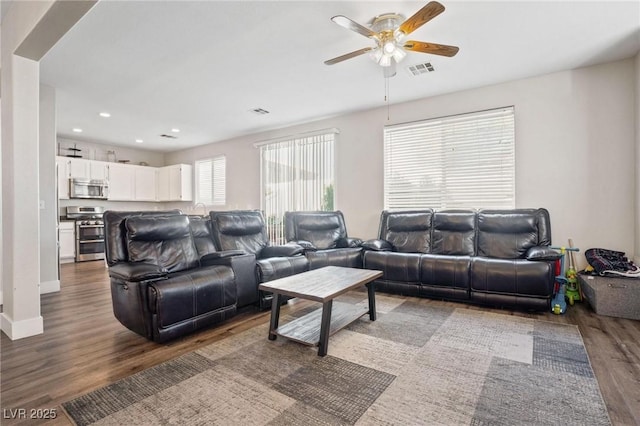 living room featuring dark hardwood / wood-style floors and ceiling fan