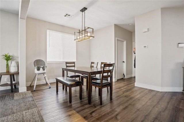 dining area featuring dark hardwood / wood-style floors and a notable chandelier