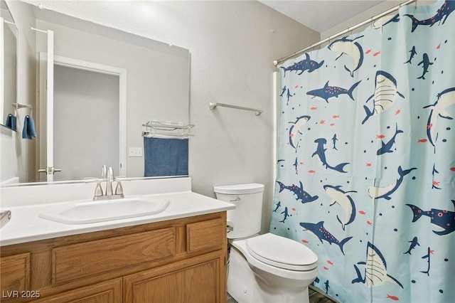 bathroom with walk in shower, vanity, and toilet