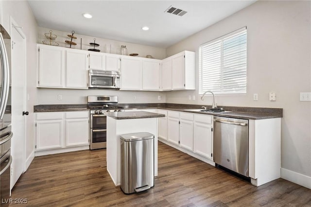 kitchen with white cabinets, sink, a kitchen island, and stainless steel appliances