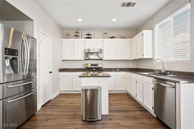 kitchen featuring white cabinetry, sink, dark hardwood / wood-style floors, a kitchen island, and appliances with stainless steel finishes