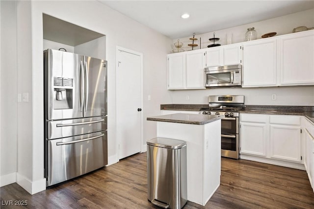 kitchen with dark hardwood / wood-style flooring, white cabinetry, and stainless steel appliances