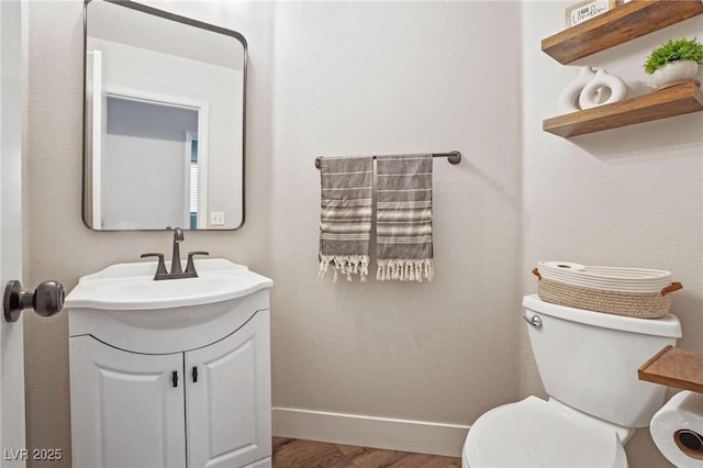 bathroom with vanity, toilet, and wood-type flooring