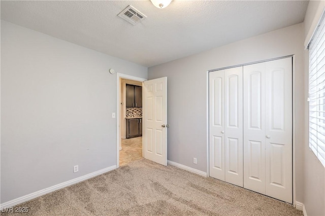 unfurnished bedroom featuring multiple windows, a closet, and light colored carpet