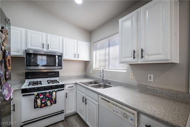 kitchen with dark hardwood / wood-style flooring, white cabinetry, sink, and appliances with stainless steel finishes