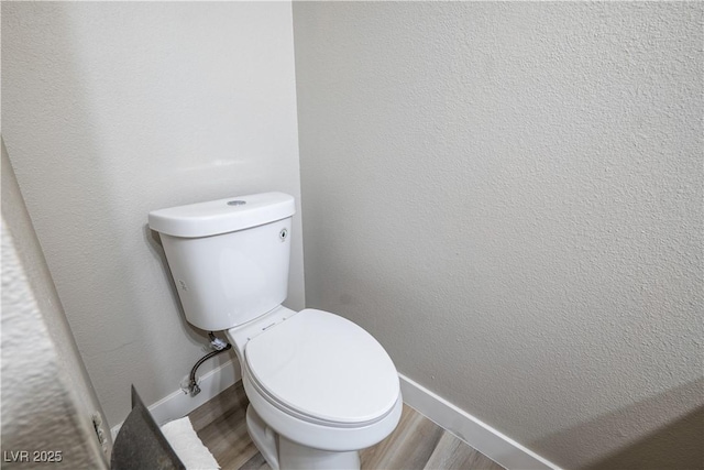 bathroom featuring hardwood / wood-style flooring and toilet