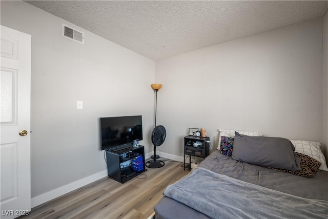 bedroom featuring hardwood / wood-style floors and a textured ceiling