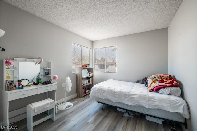 bedroom featuring wood-type flooring and a textured ceiling