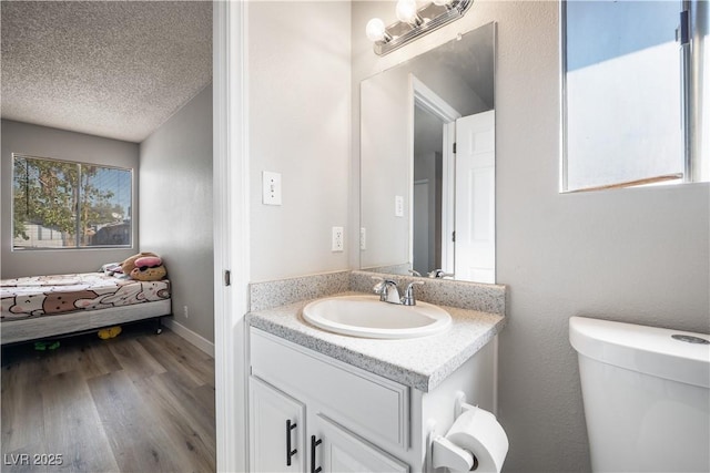 bathroom with vanity, a textured ceiling, hardwood / wood-style flooring, and toilet