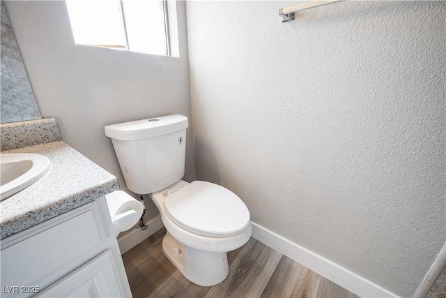 bathroom featuring vanity, wood-type flooring, and toilet