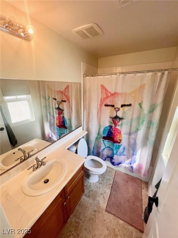 bathroom with vanity, curtained shower, and toilet