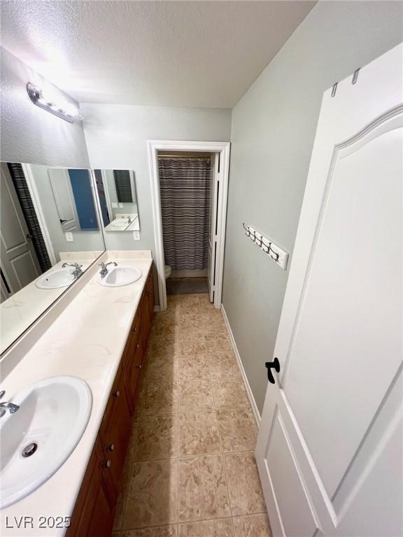 bathroom with vanity, toilet, and a textured ceiling