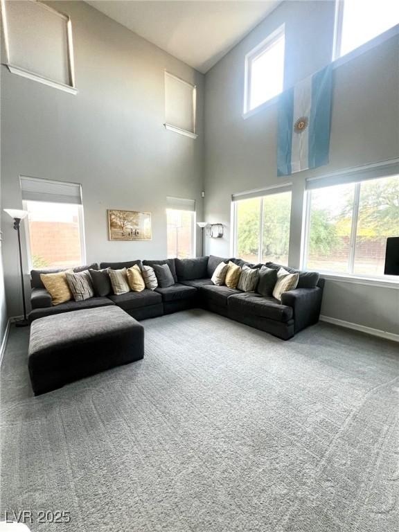 carpeted living room featuring a high ceiling