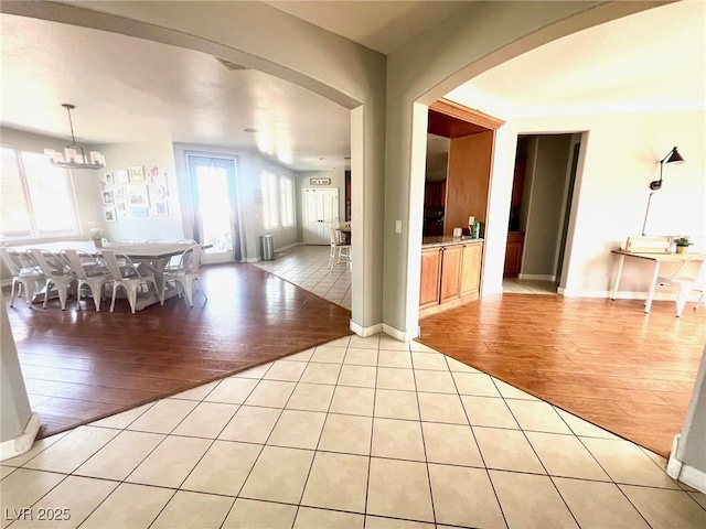 unfurnished dining area with a notable chandelier and light hardwood / wood-style flooring