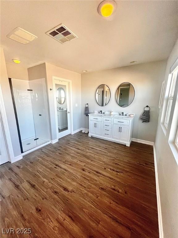 interior space featuring wood-type flooring, a shower, and vanity