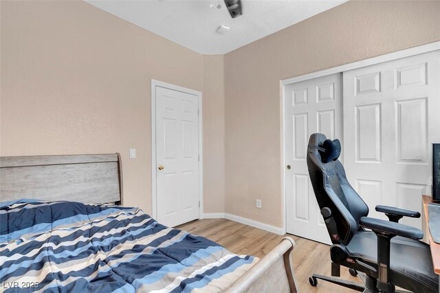 bedroom with light wood-type flooring and a closet