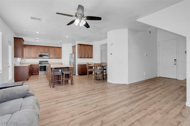 living room featuring ceiling fan and light hardwood / wood-style flooring