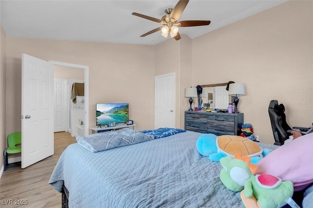 bedroom featuring ceiling fan, light wood-type flooring, and lofted ceiling