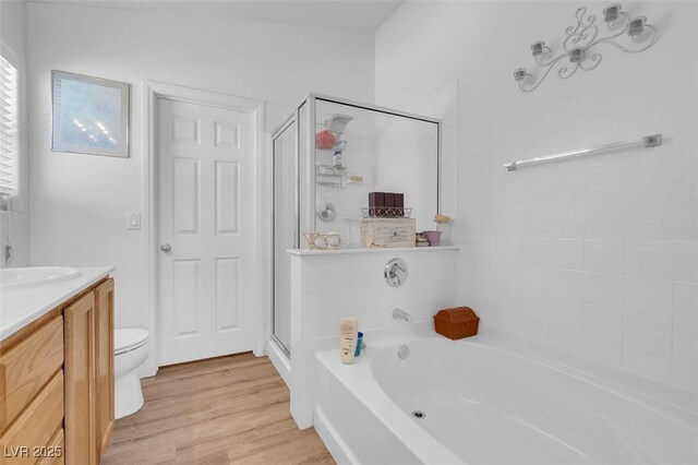 full bathroom with hardwood / wood-style flooring, vanity, toilet, and plus walk in shower