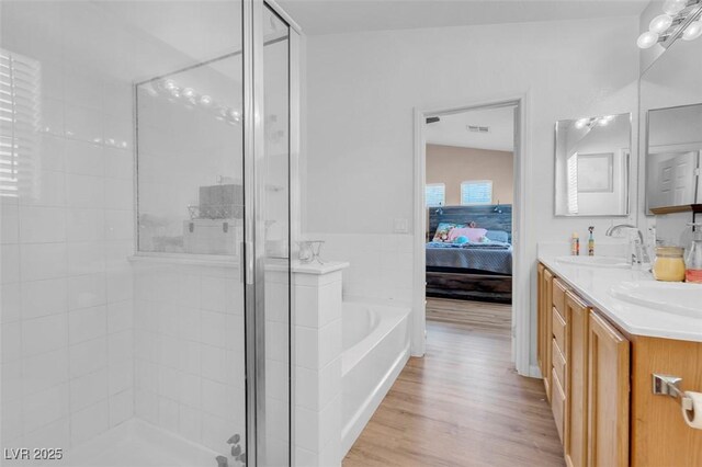 bathroom with separate shower and tub, vanity, wood-type flooring, and lofted ceiling