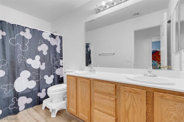 bathroom with hardwood / wood-style flooring, vanity, and toilet