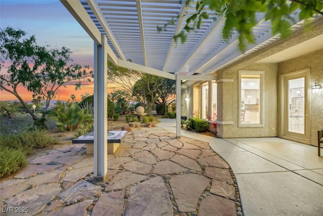 patio terrace at dusk featuring a pergola