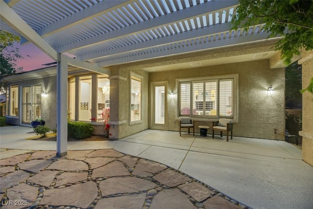 patio terrace at dusk featuring a pergola