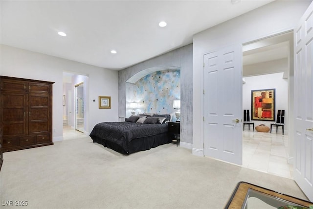 bedroom with ensuite bathroom and light colored carpet