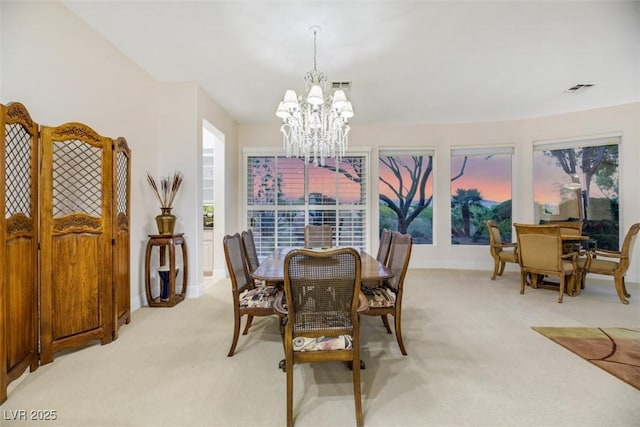 carpeted dining space with a notable chandelier