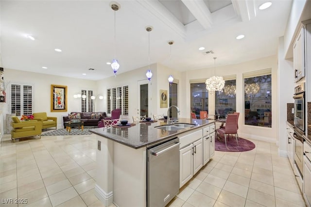 kitchen featuring light tile patterned flooring, sink, decorative light fixtures, appliances with stainless steel finishes, and white cabinets