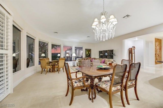 carpeted dining area with a notable chandelier