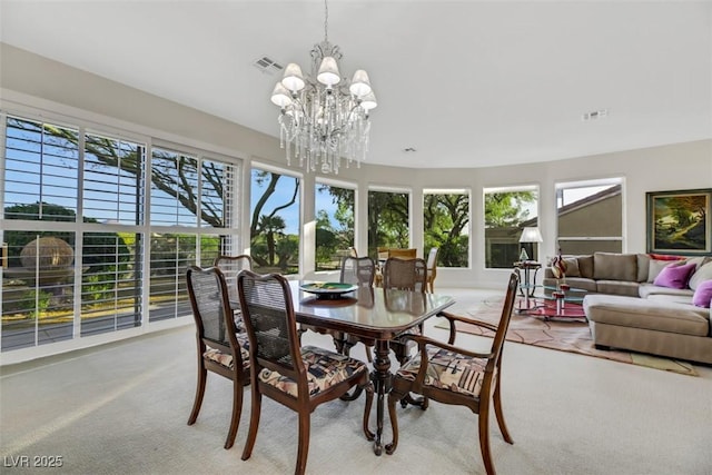 carpeted dining room featuring an inviting chandelier