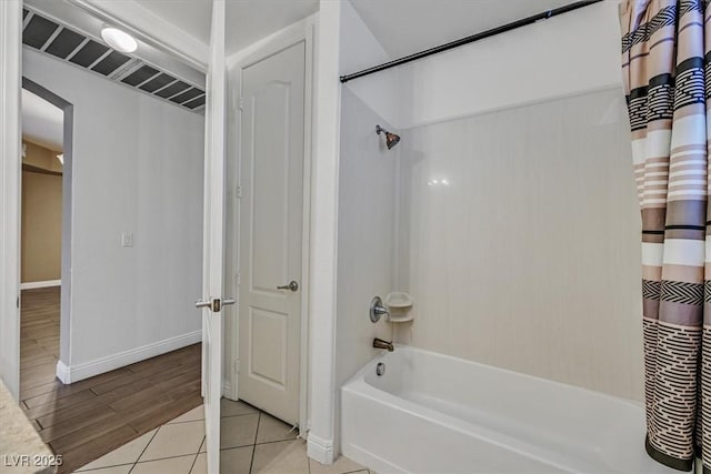 full bath with baseboards, shower / bath combo, and tile patterned floors