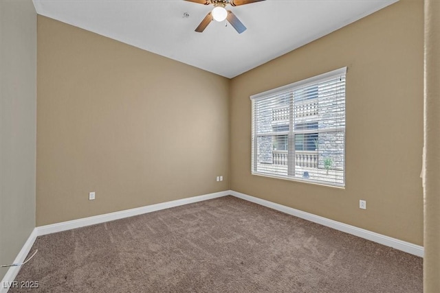 carpeted spare room with a ceiling fan and baseboards