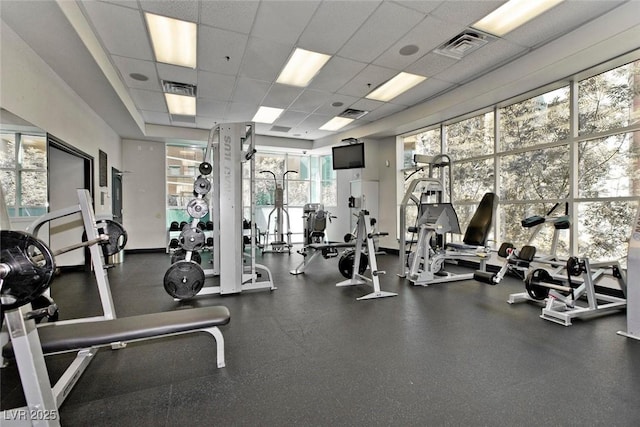 workout area with visible vents and a paneled ceiling