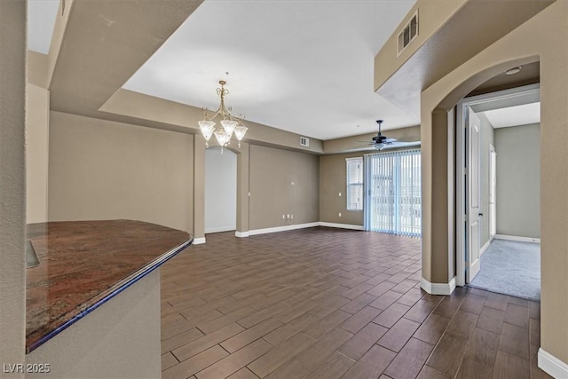 unfurnished living room with ceiling fan with notable chandelier