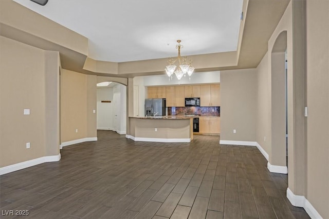 kitchen featuring arched walkways, open floor plan, dark wood-type flooring, light brown cabinetry, and black appliances