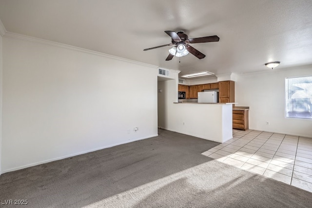 unfurnished living room with ceiling fan, ornamental molding, and light carpet