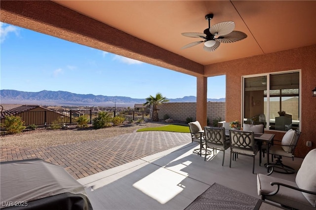 view of patio / terrace with ceiling fan and a mountain view