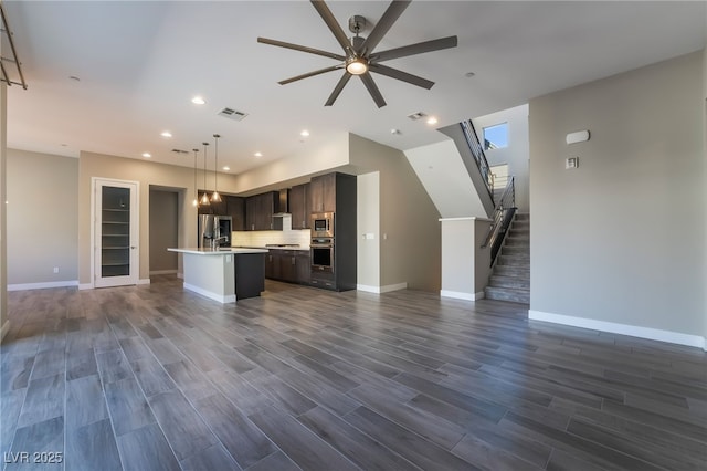 kitchen featuring a center island with sink, dark hardwood / wood-style floors, stainless steel appliances, and dark brown cabinetry