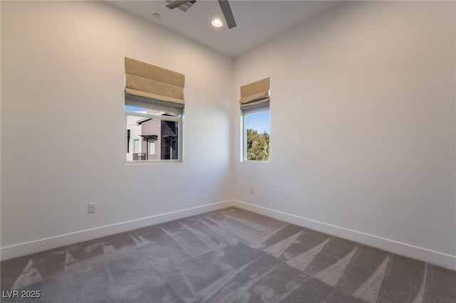 unfurnished room featuring ceiling fan and dark carpet