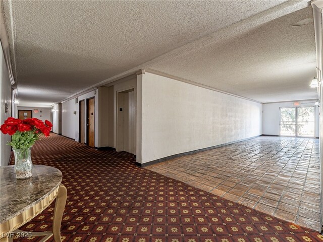 corridor featuring ornamental molding and a textured ceiling